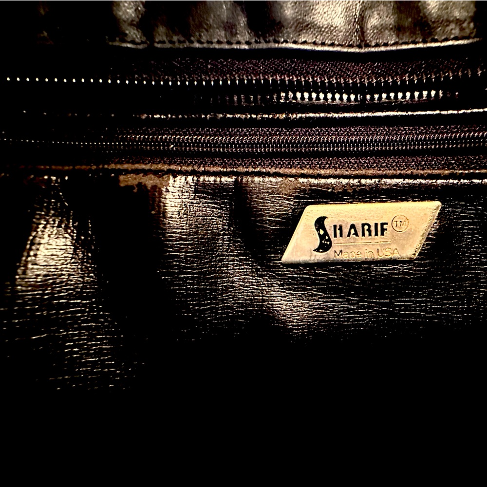 Sharif leather purse. Knick on one strap,wear on a braiding.